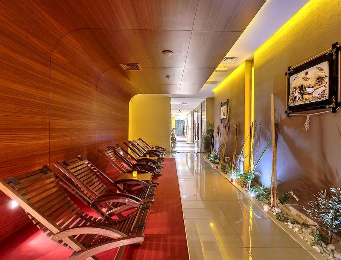 Innenbereich eines Hotels mit Holz-Loungesesseln und einem roten Teppich