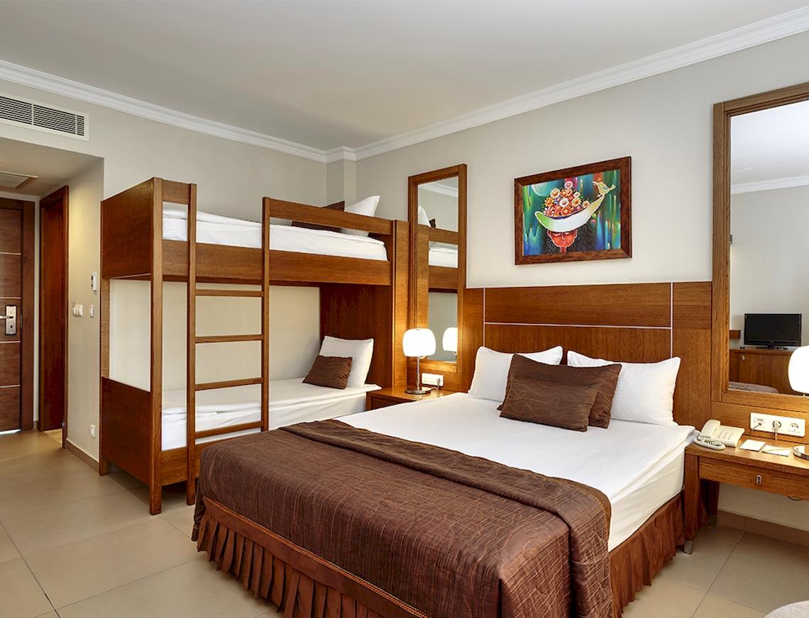 Hotelzimmer mit Doppelstockbetten und Nachttisch im Sunis Elita Beach Resort Hotel & Spa.