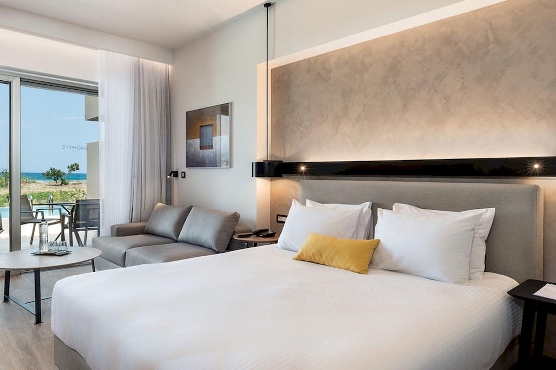 Euphoria Resort Hotelzimmer mit Bett, Sofa und Blick auf den Pool