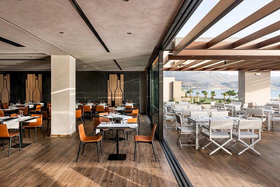 Innenansicht des Restaurants im Euphoria Resort mit Blick auf den Garten und das Meer.
