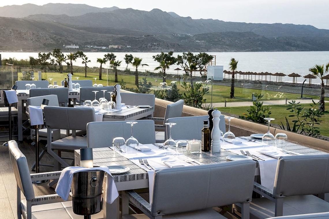 Aussenbereich des Euphoria Resorts mit Tisch und Stuhl und Meerblick.