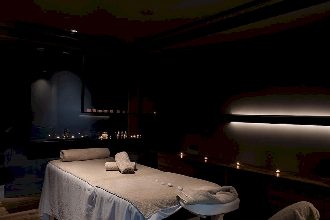 Spa-Behandlungsraum im Euphoria Resort mit vorbereiteter Massageliege und warmen Lichtakzenten.
