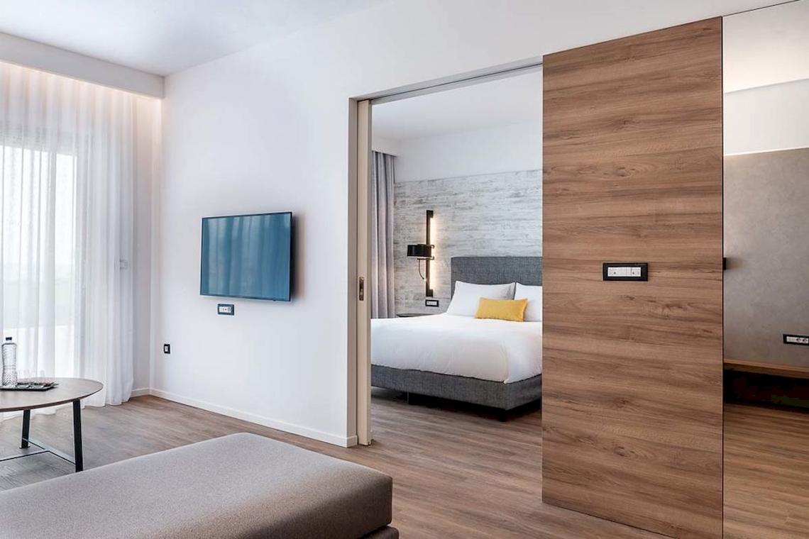Innenansicht eines Zimmers im Euphoria Resort Hotel mit Fernseher, Bett und Tisch.