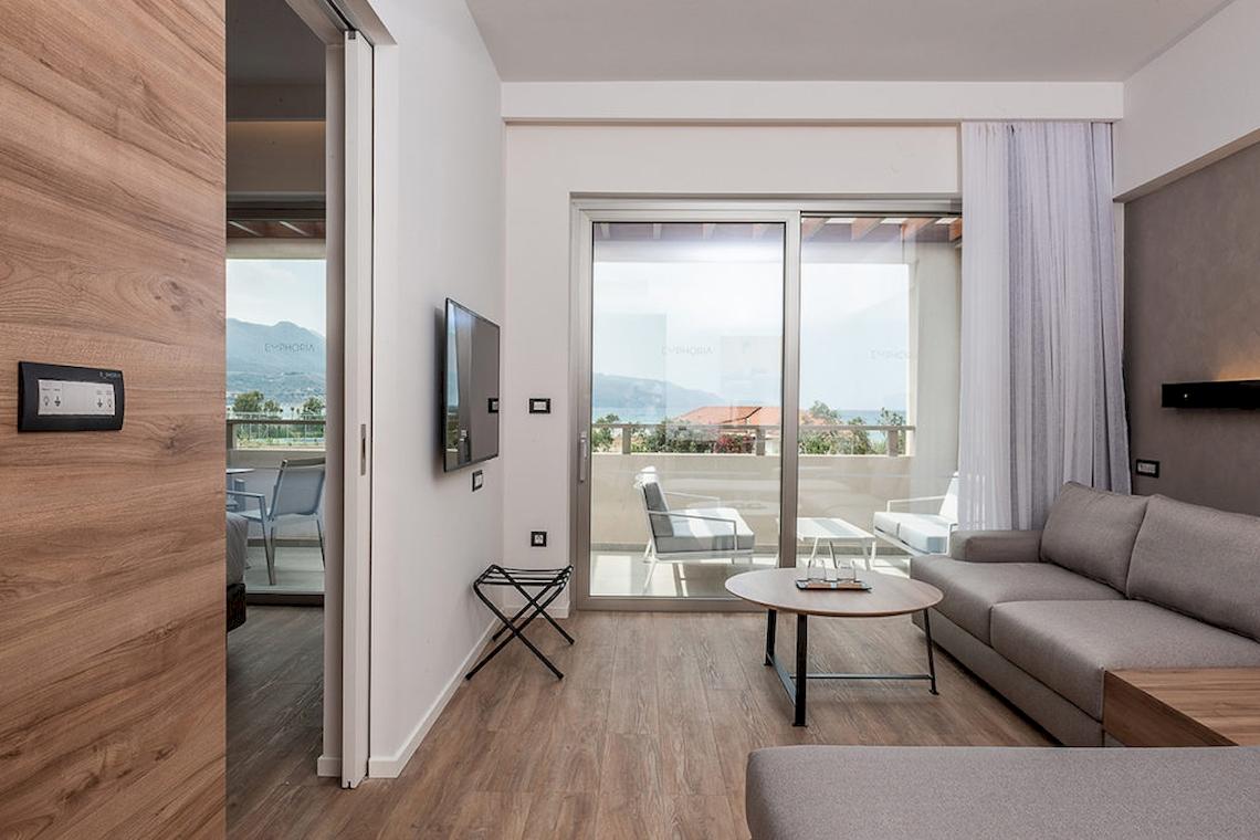 Wohnzimmer des Euphoria Resorts mit Balkon, Fernseher und Möbeln.