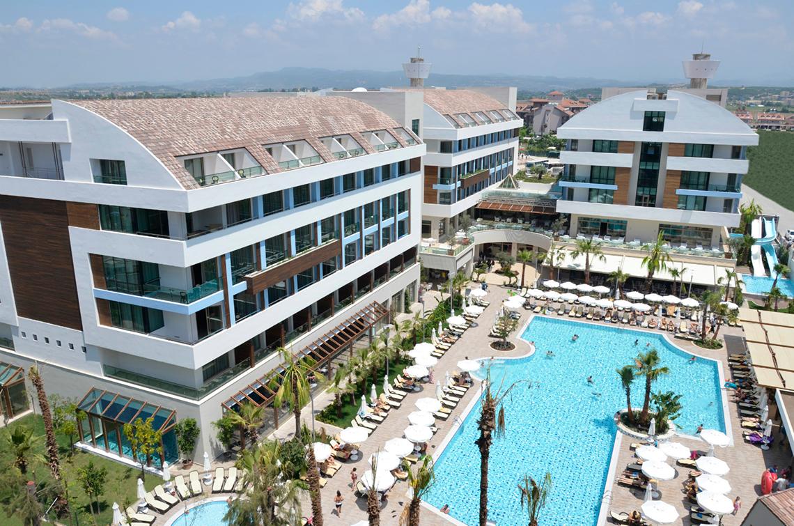 Luftaufnahme des Port Side Resorts mit mehreren Gebäuden und Swimmingpools.