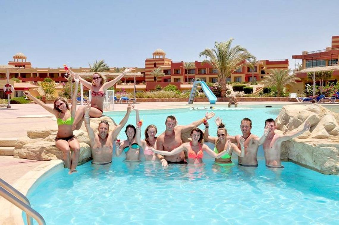 Eine Gruppe von Urlaubern posiert am Pool im Malikia Resort Abu Dabbab.