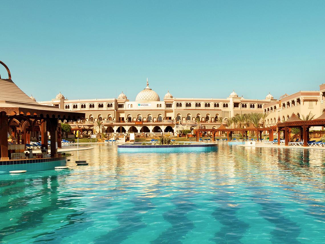 Außenansicht des Sentido Mamlouk Palace Hotels mit großem Swimmingpool und Sonnenliegen.