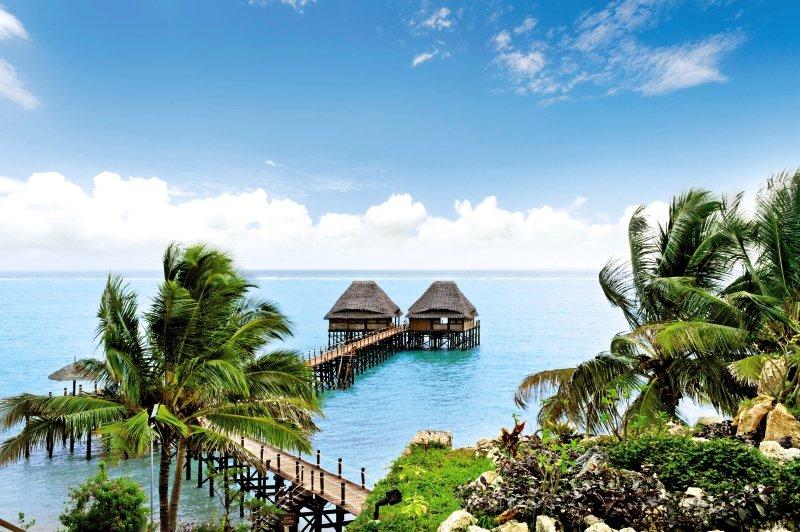 Zwei traditionelle afrikanische Hütten am Wasser des Melia Zanzibar Hotels
