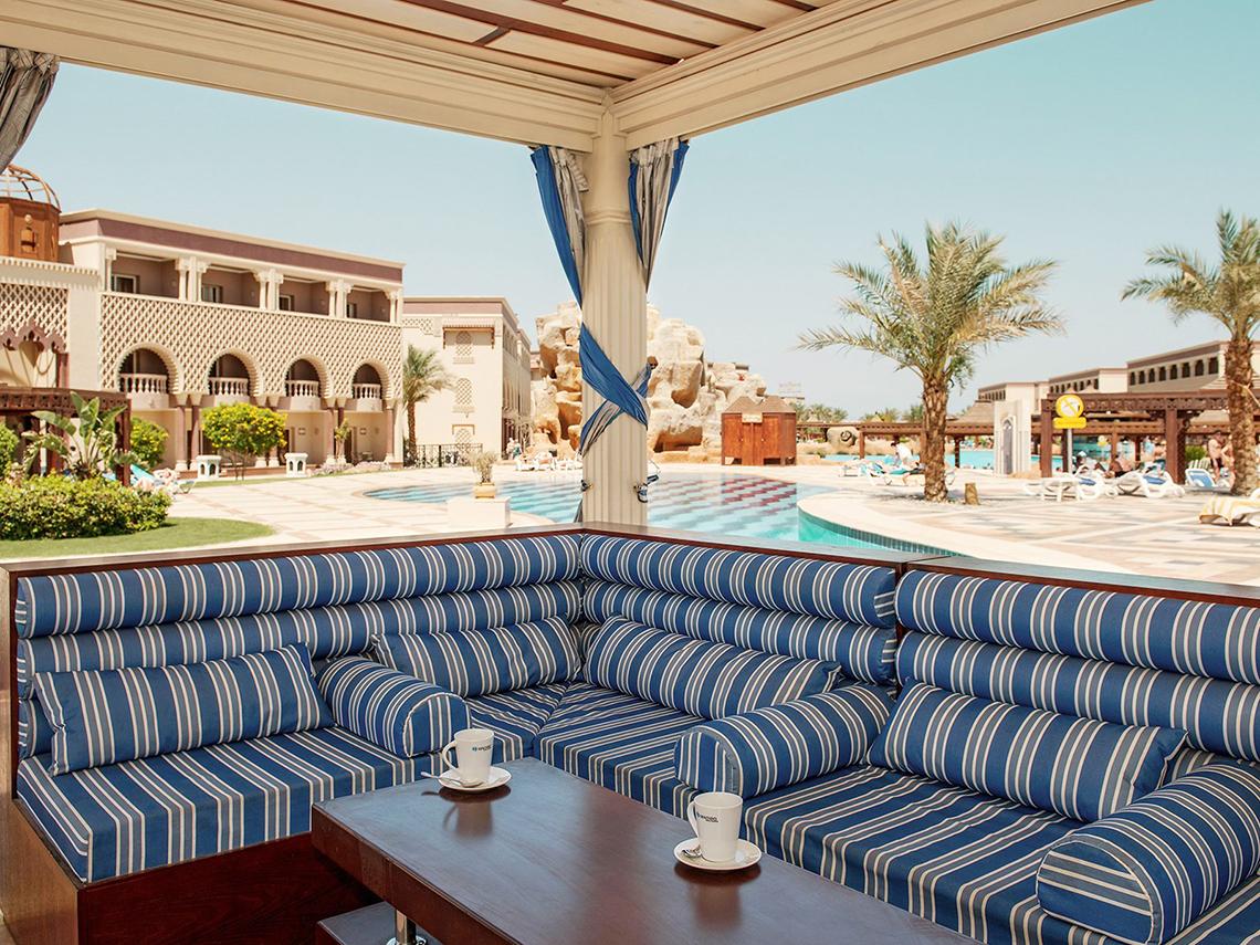 Terrasse des Sentido Mamlouk Palace Hotels mit Blick auf den Pool und die Anlage.