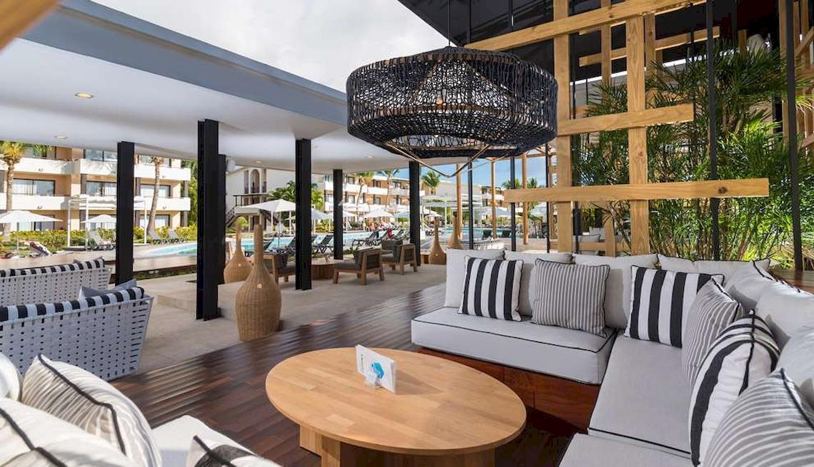 Hotellounge mit Blick auf den Pool und modernen Möbeln, hängende Laterne.