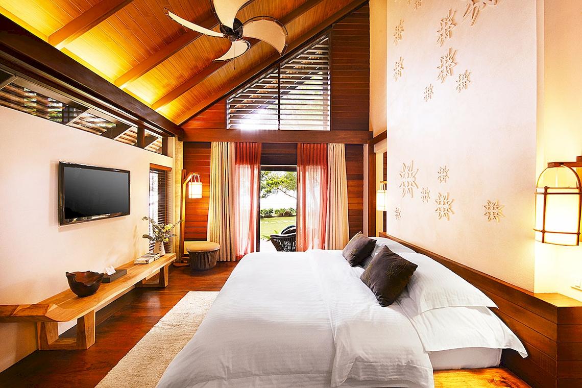 Schlafzimmer im Tubkaak Krabi Boutique Resort mit Bett, Fernseher und Holzmöbeln