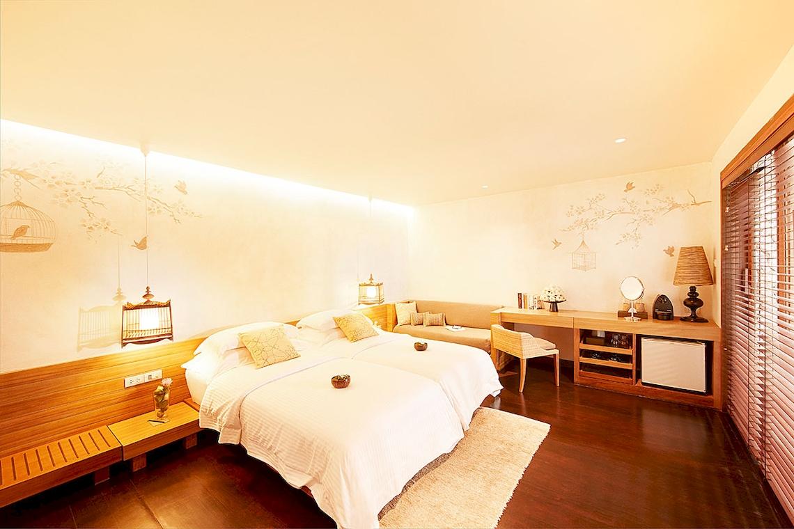 Schlafzimmer im Tubkaak Krabi Boutique Resort mit zwei Betten, Dekor und Möbeln.