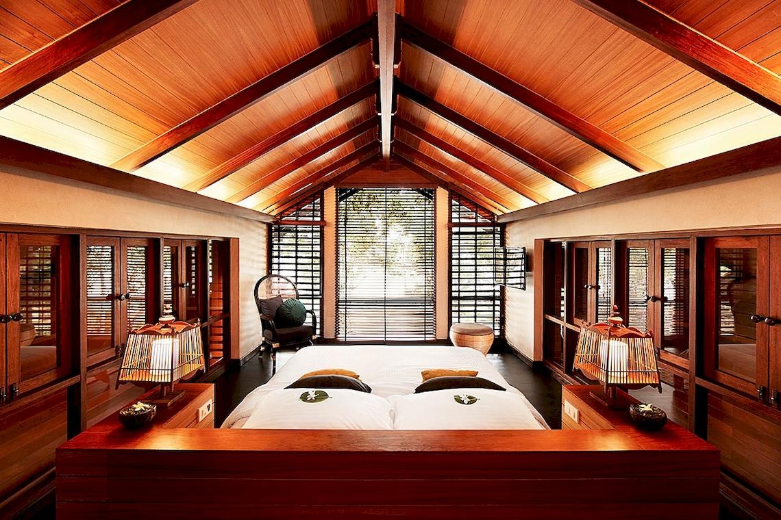 Schlafzimmer im Tubkaak Krabi Boutique Resort mit zwei Betten und Holzmöbeln.