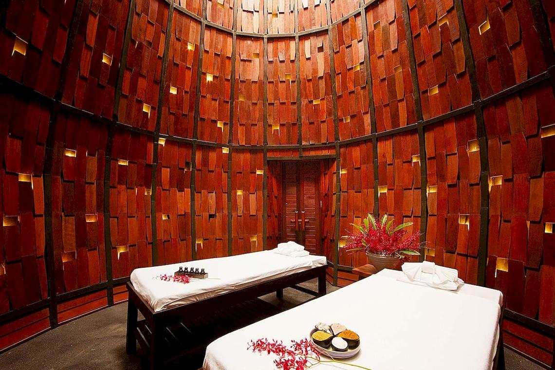 Massageraum im Tubkaak Krabi Boutique Resort mit zwei Liegen und roten Blumendekor.