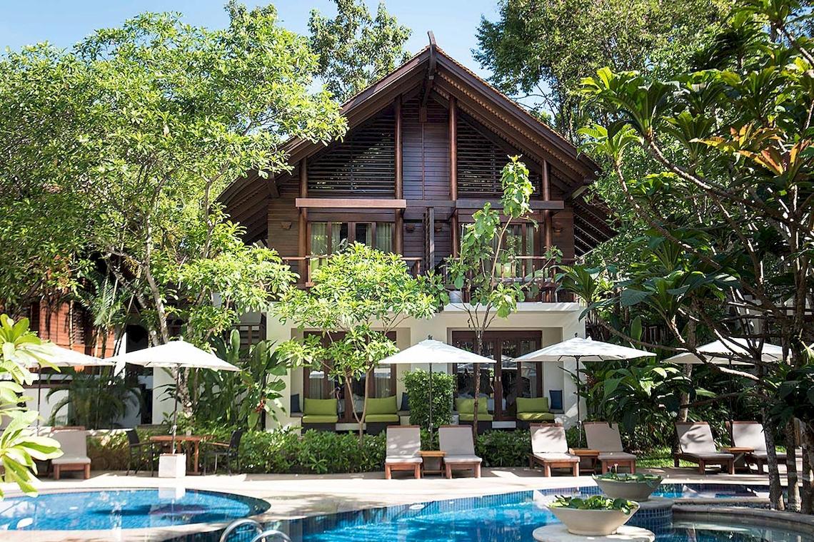 Außenbereich des Tubkaak Krabi Boutique Resorts mit Swimmingpool und Sonnenliegen.