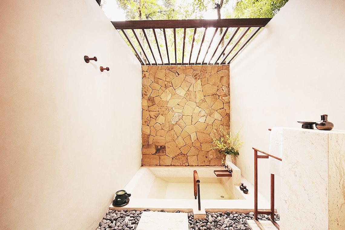 Badezimmer mit Badewanne und Steinwand im Tubkaak Krabi Boutique Resort
