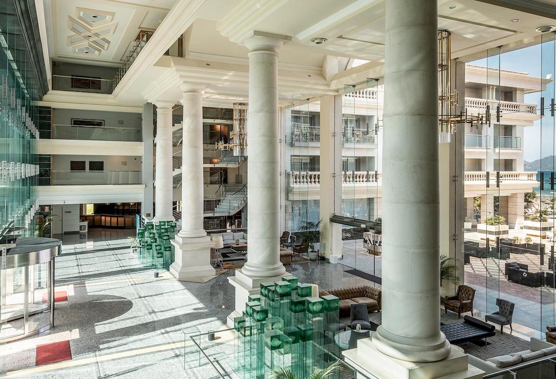 Sarena de Muro Resort Mallorca Hotellobby mit hohen Säulen und modernen Möbeln.