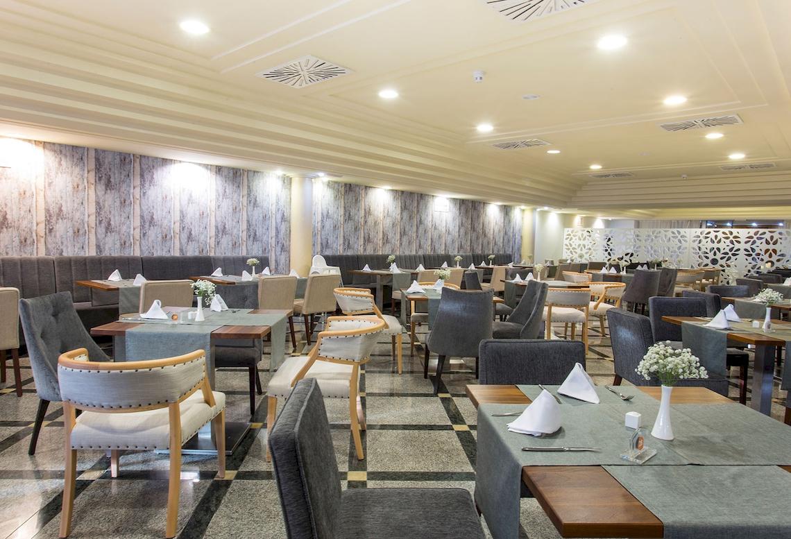 Restaurant des Sarena de Muro Resorts auf Mallorca mit gepolsterten Bänken und gedeckten Tischen.