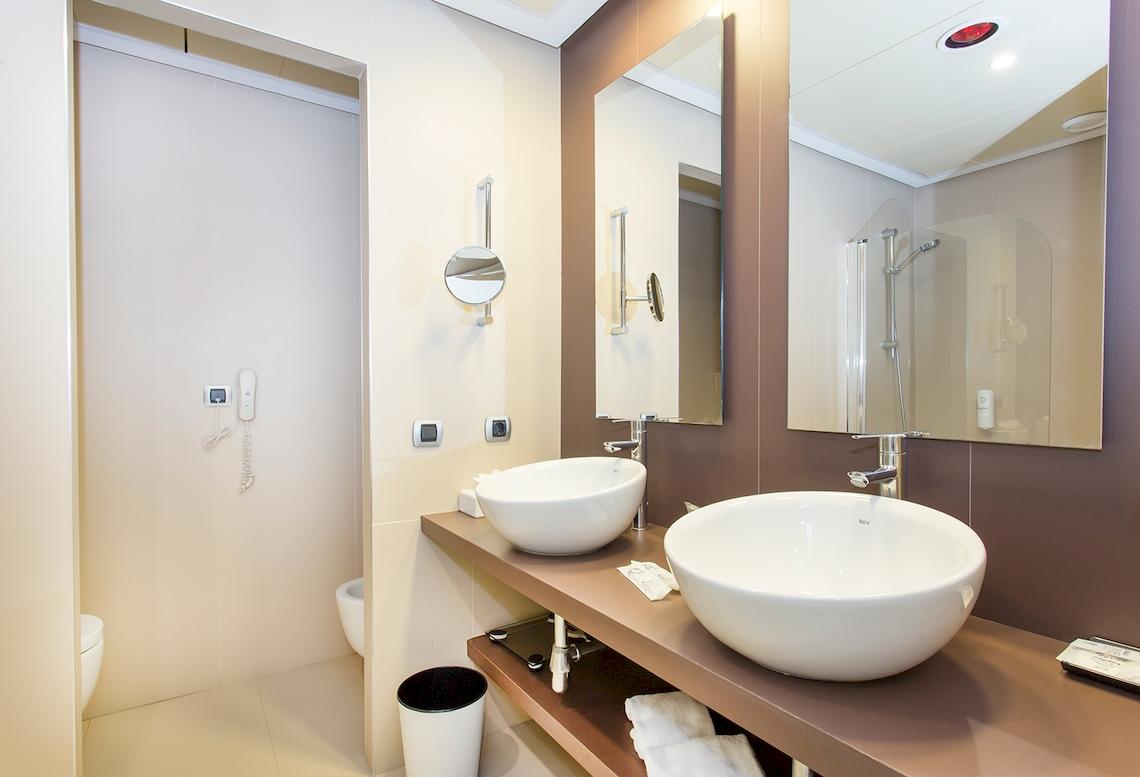 Badezimmer im Sarena de Muro Resort Mallorca mit zwei Waschbecken und Spiegeln.