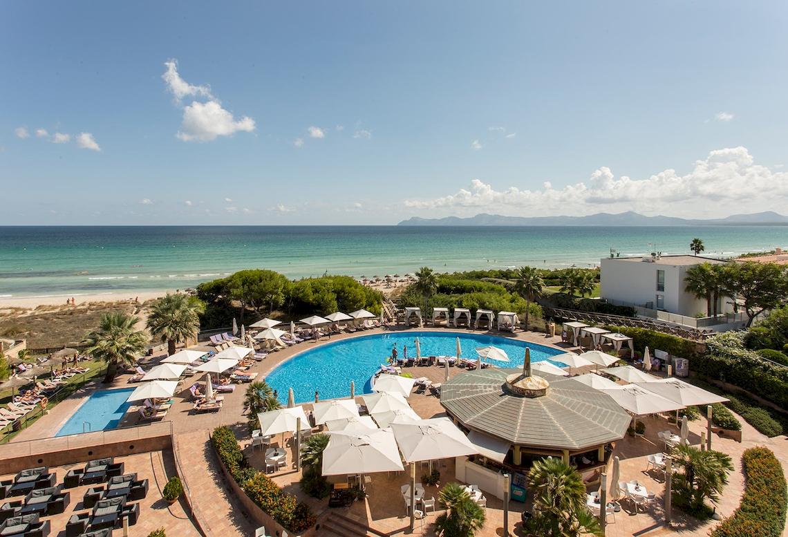 Luftaufnahme des Sarena de Muro Resort Mallorca mit Pool und Strand im Hintergrund.