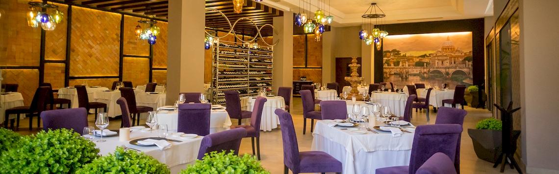 Innenraum des El Dorado Royale a Spa Resort by Karisma mit eingerichteten Tischen und Stühlen.