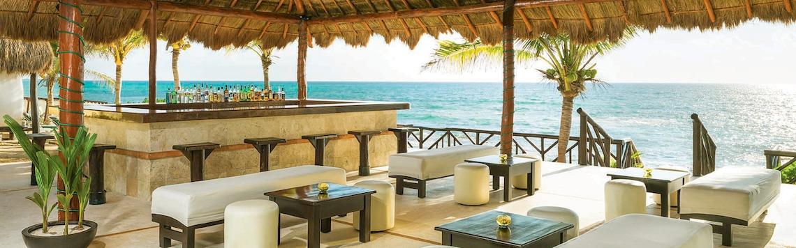Außenbar des El Dorado Royale a Spa Resort mit Blick auf das Meer und tropischer Dekoration.