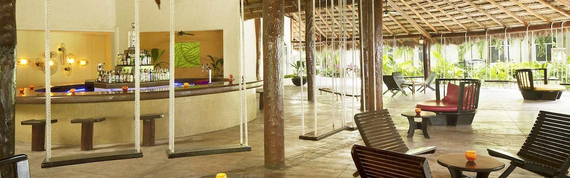 Barbereich des El Dorado Royale a Spa Resort by Karisma mit Hängestühlen und Sitzgelegenheiten.
