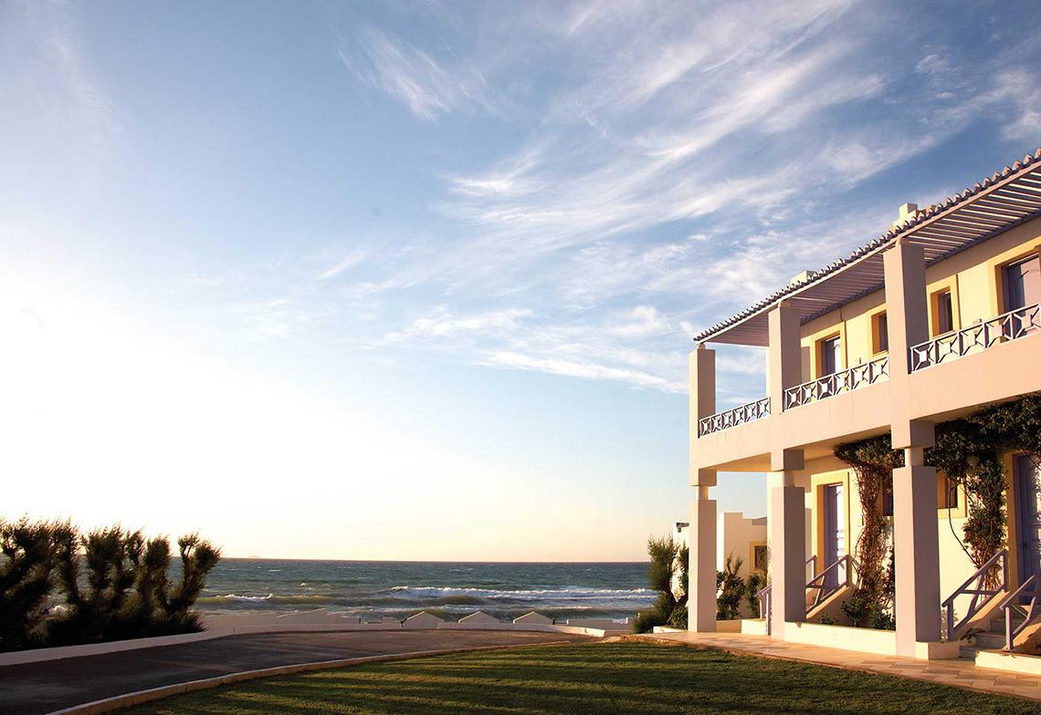 Außenansicht des Serita Beach Hotels mit Blick auf das Meer und eine Wiese