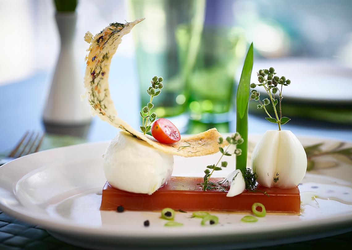 Gedeckter Tisch im Serita Beach Hotel mit einem Gericht aus Mozzarella, Tomaten und Gemüse.