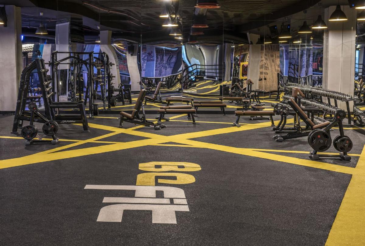 Fitnesscenter im Delphin BE Grand Resort mit gelben Linien und großen Buchstaben.
