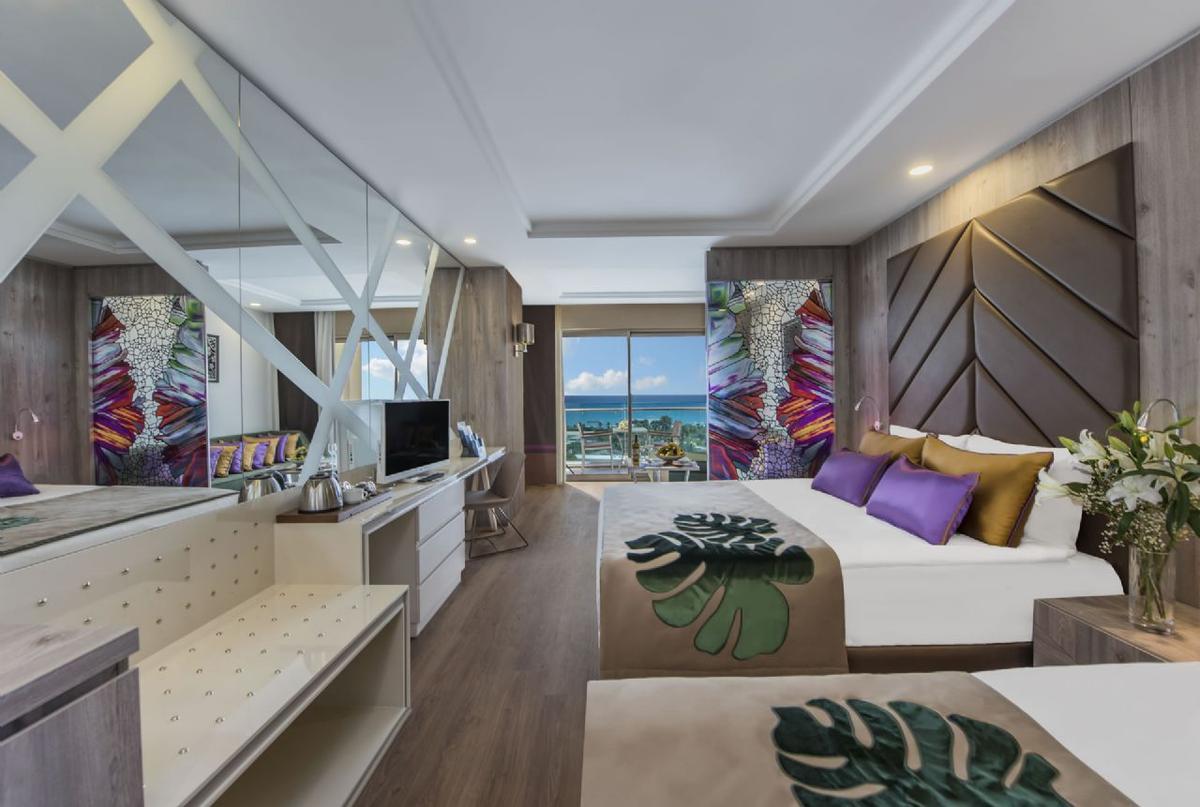 Suite Zimmer im Delphin BE Grand Resort mit Meerblick und modernen Möbeln.