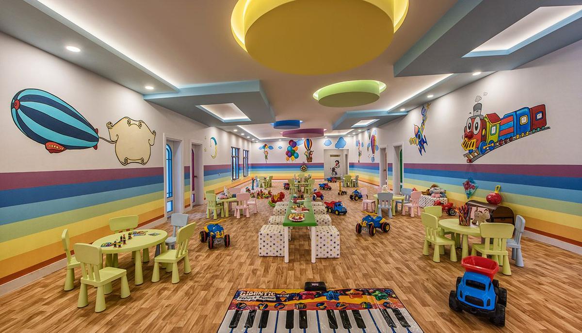 Kinderzimmer im Delphin BE Grand Resort mit bunten Wänden und Spielzeug.