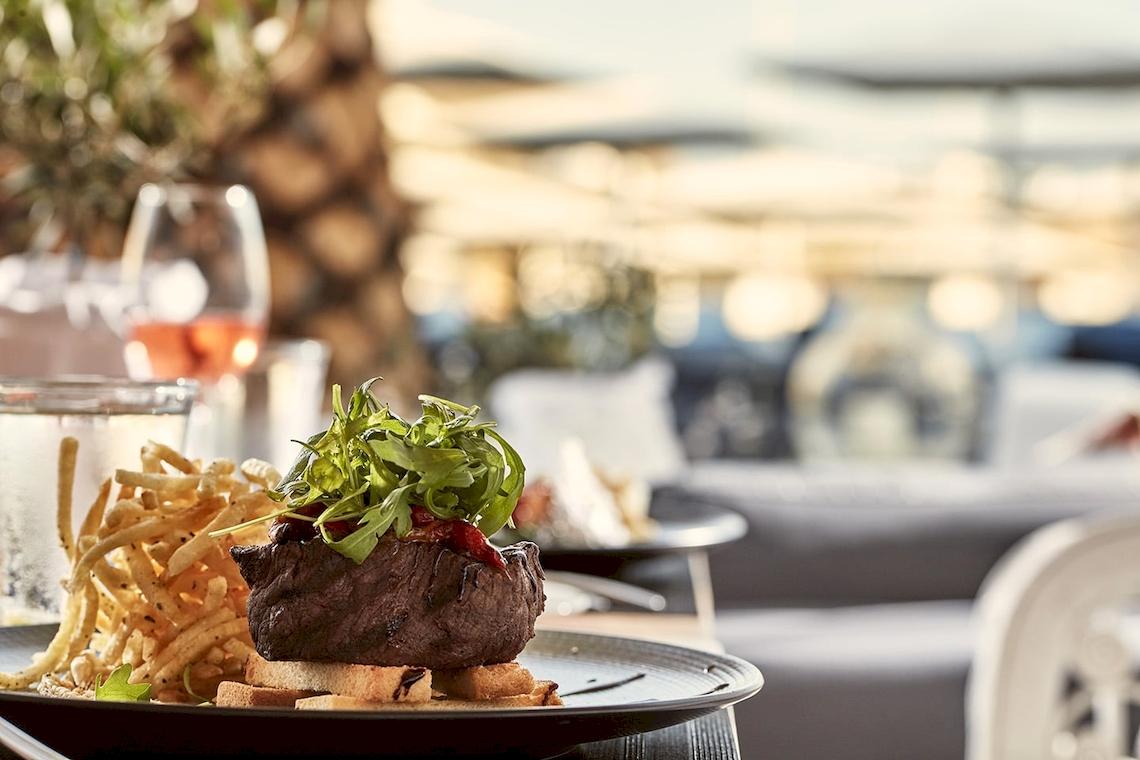 Grillsteak mit Beilagen auf der Terrasse im Mykonos Ammos Hotel