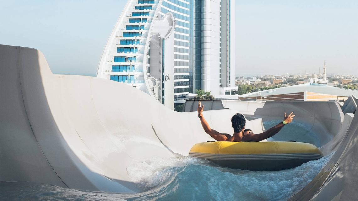 Mann in einem gelben Schlauchboot auf einer Wasserrutsche im Jumeirah Mina A'Salam