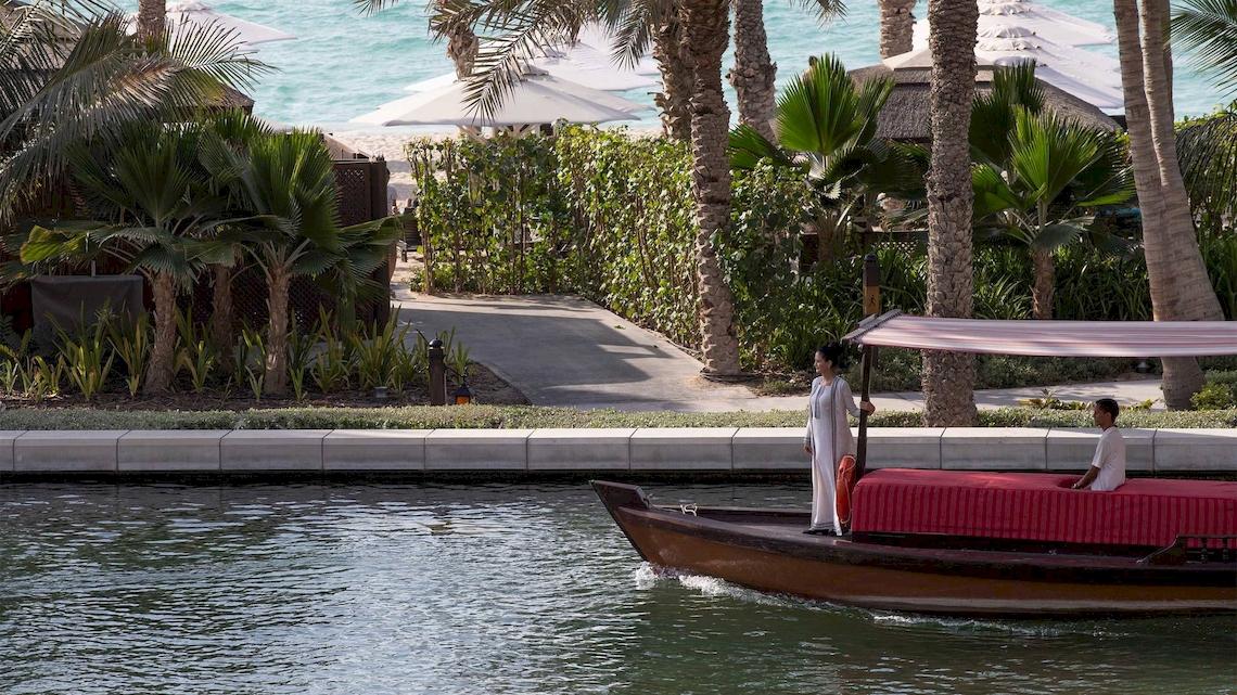 Zwei Personen genießen eine Bootsfahrt am Jumeirah Mina A'Salam Hotel.