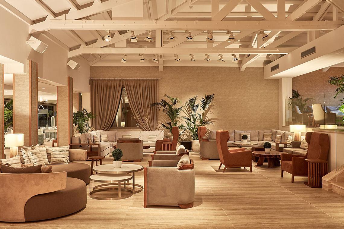 Innenansicht des Mare Ayia Napa Hotels mit vielen Sofas, Tischen, Lampen und Pflanzen.