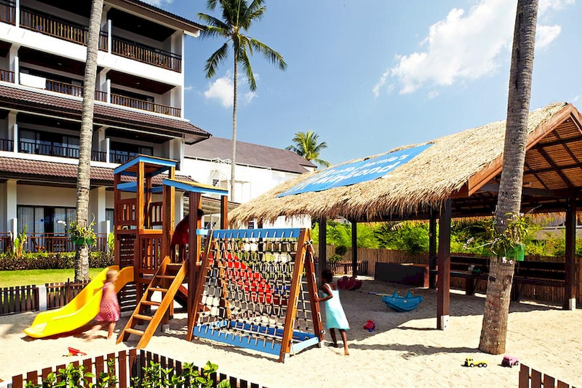 Spielplatz vor dem Sunwing Kamala Beach Hotel mit Gebäude und Kindern, die spielen