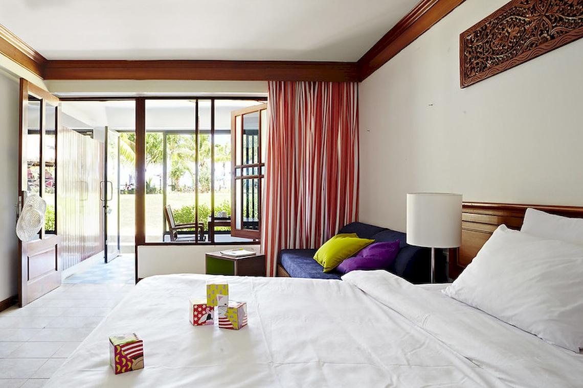 Hotelzimmer im Sunwing Kamala Beach mit Bett, Sofa und Fenstern.