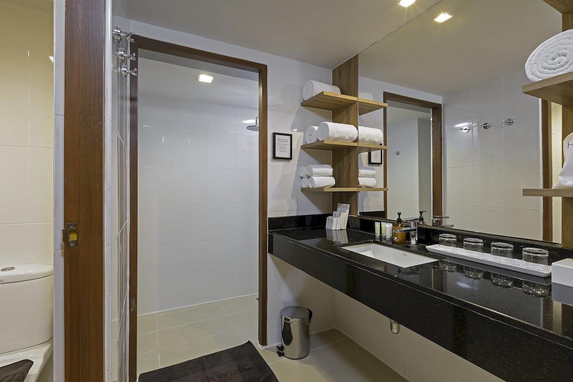 Badezimmer im Sunwing Kamala Beach Hotel mit Duschbereich, Waschbecken und Toilette.