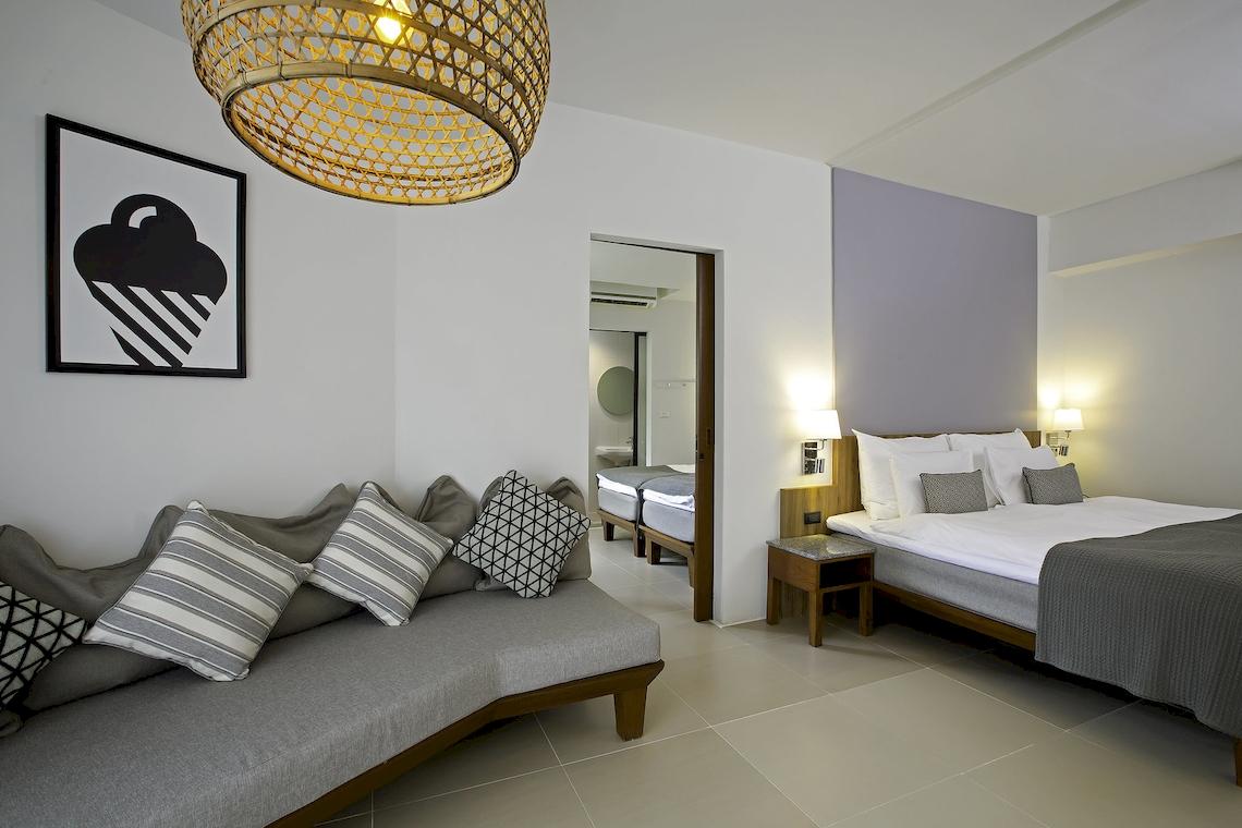 Hotelzimmer im Sunwing Kamala Beach mit Bett, Sofa und modernem Dekor.