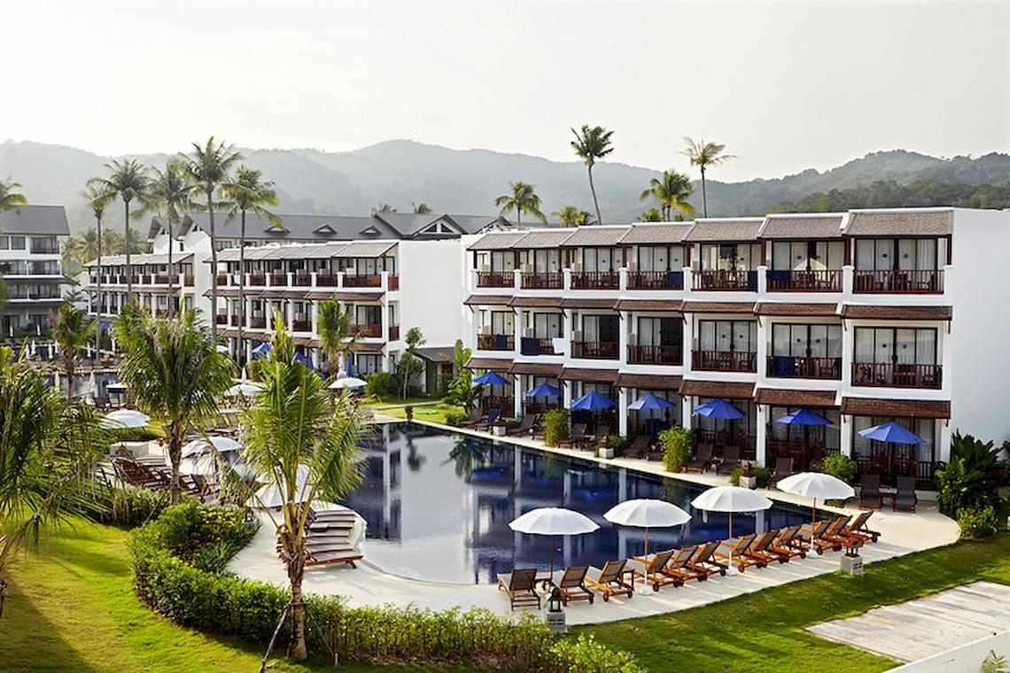 Luftaufnahme des Sunwing Kamala Beach Hotels mit Pool, Liegestühlen und Sonnenschirmen.