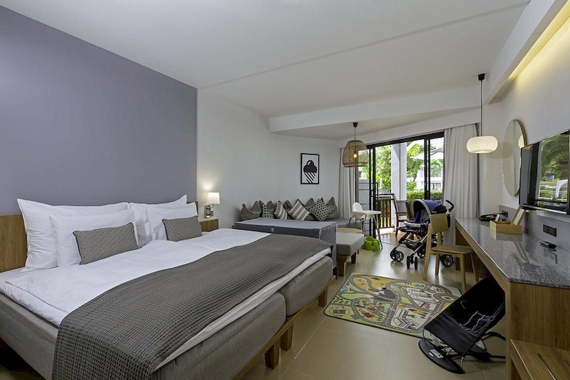 Hotelzimmer im Sunwing Kamala Beach mit Doppelbett, Wohnzimmerbereich und Terrasse.