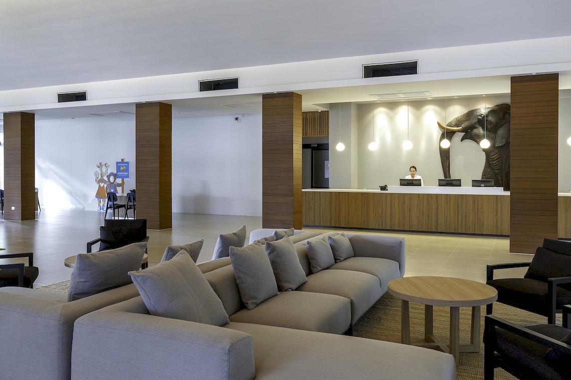 Empfangsbereich des Sunwing Kamala Beach Hotels mit Rezeption und Möbeln.