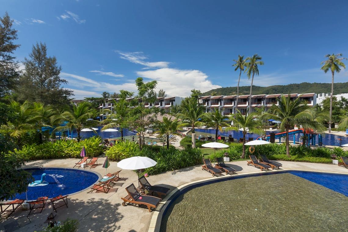 Luftaufnahme des Sunwing Kamala Beach Hotels mit Swimmingpool, Liegestühlen und Sonnenschirmen.