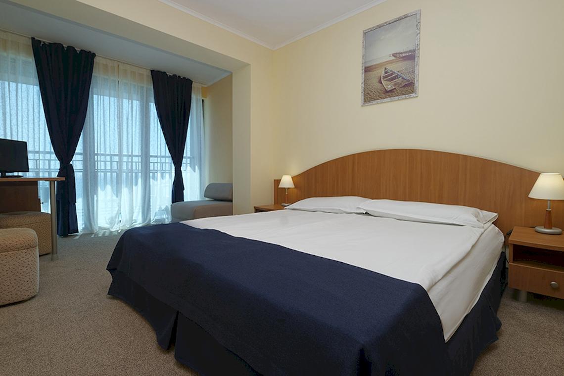 Schlafzimmer im Bellevue Hotel mit Doppelbett, Nachttischen und Lampen.