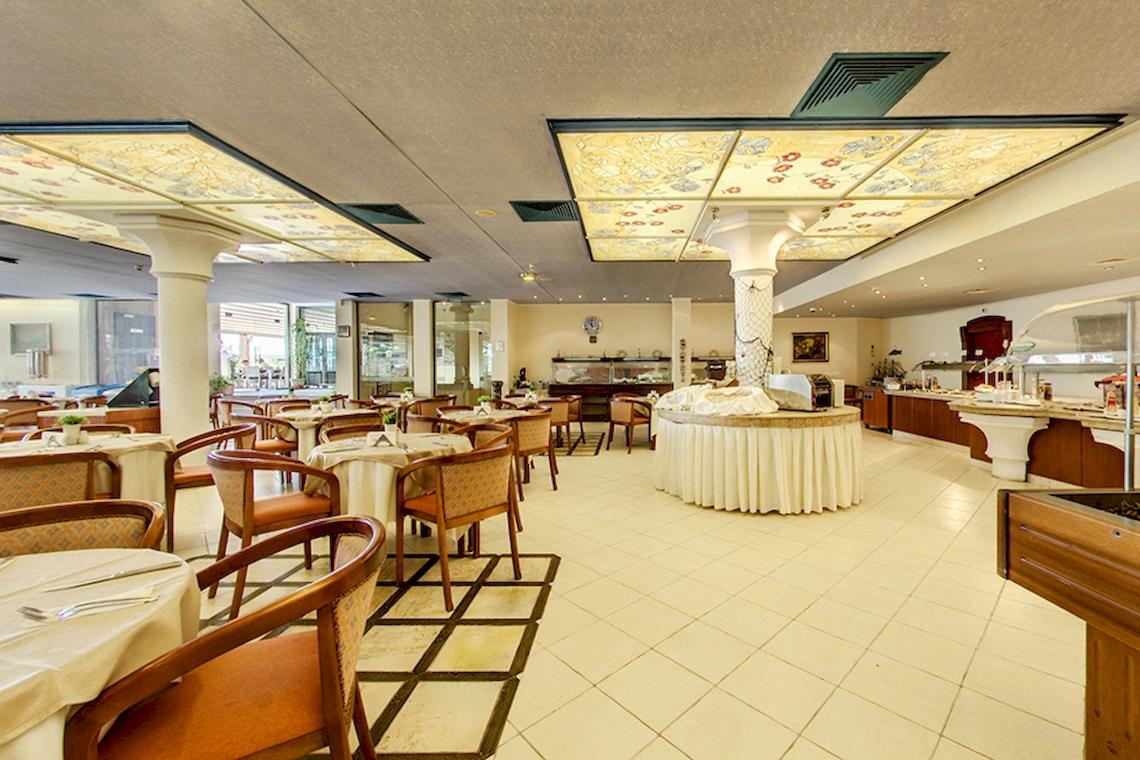 Innenbereich des Bellevue Hotels mit gefliestem Boden und gedeckten Tischen.