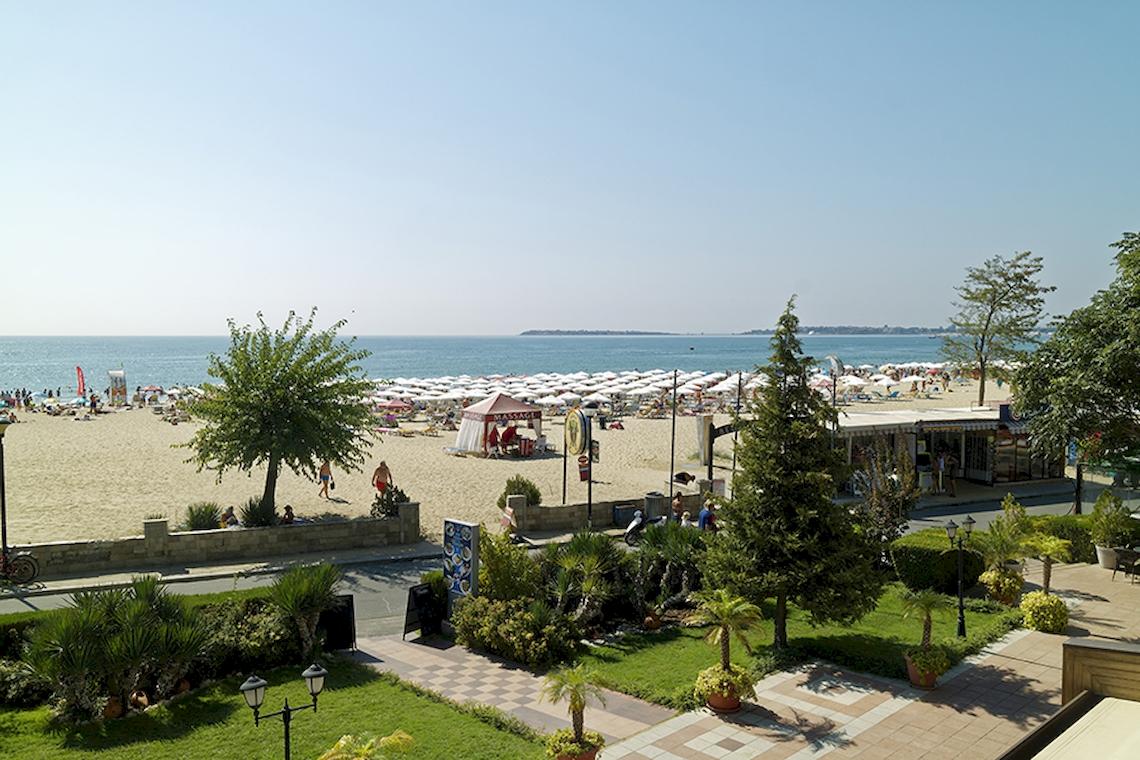 Aussicht auf den Strand vom Bellevue Hotel mit vielen Sonnenschirmen und Gästen.