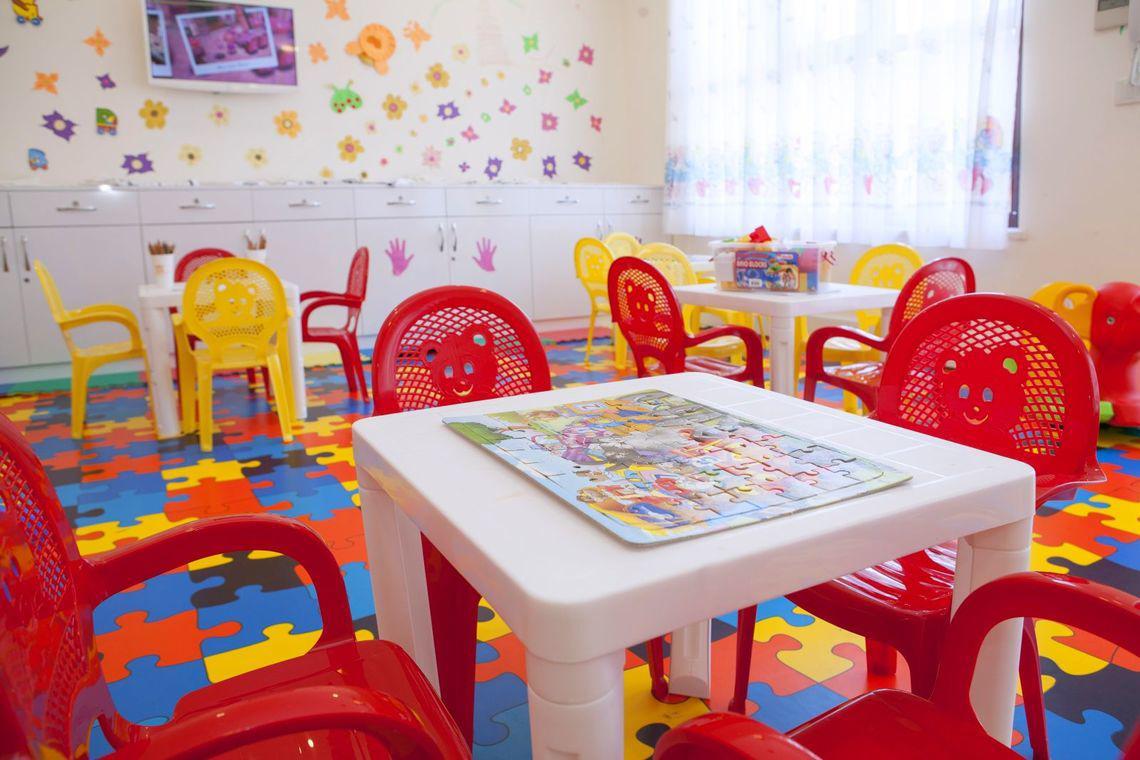 Kinderzimmer im Side Orange Palace Hotel mit bunten Stühlen und Puzzle auf dem Tisch.