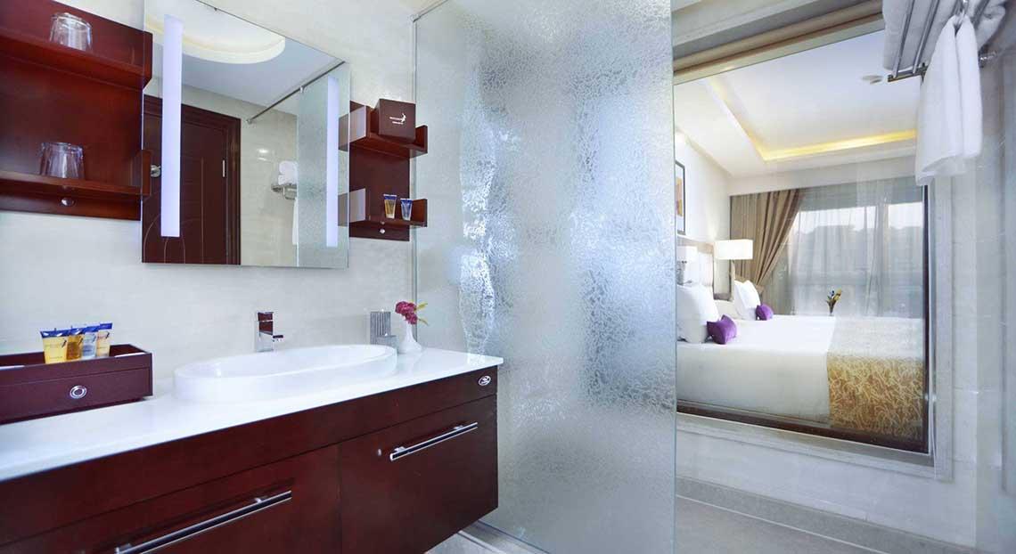 Badezimmer-Ansicht des Pickalbatros White Beach Resort Hotelzimmers mit Waschbecken und Spiegel.