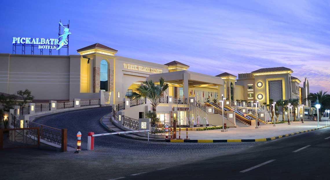 Außenansicht des Pickalbatros White Beach Resort bei Nacht mit Beleuchtung und Hotelname